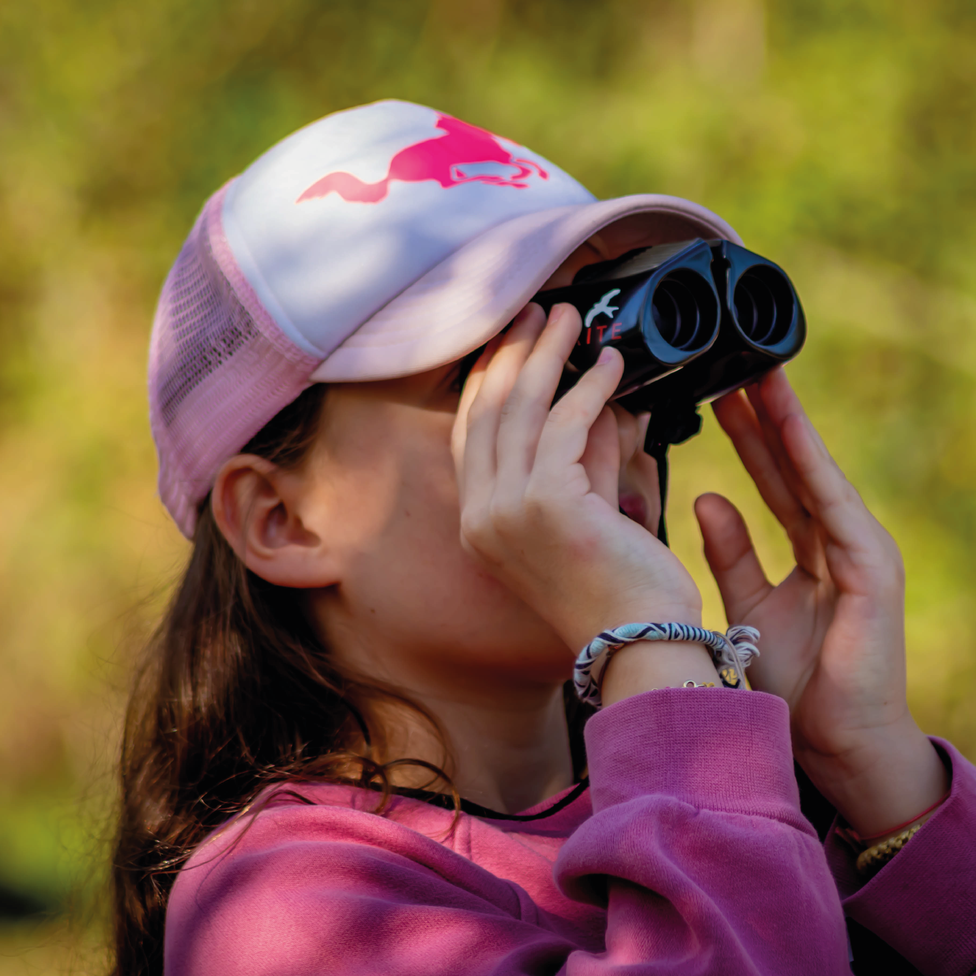 Young girl using binoculars to birdwatch.