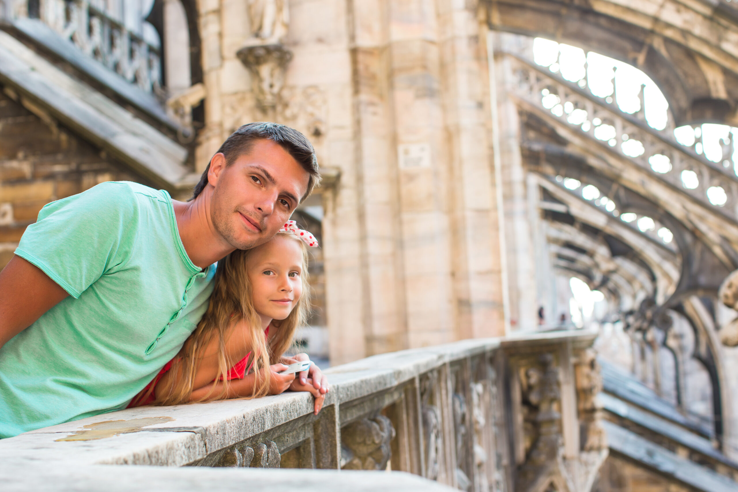 Adorable little girl with father on rooftop of Duomo, Milan, Italy